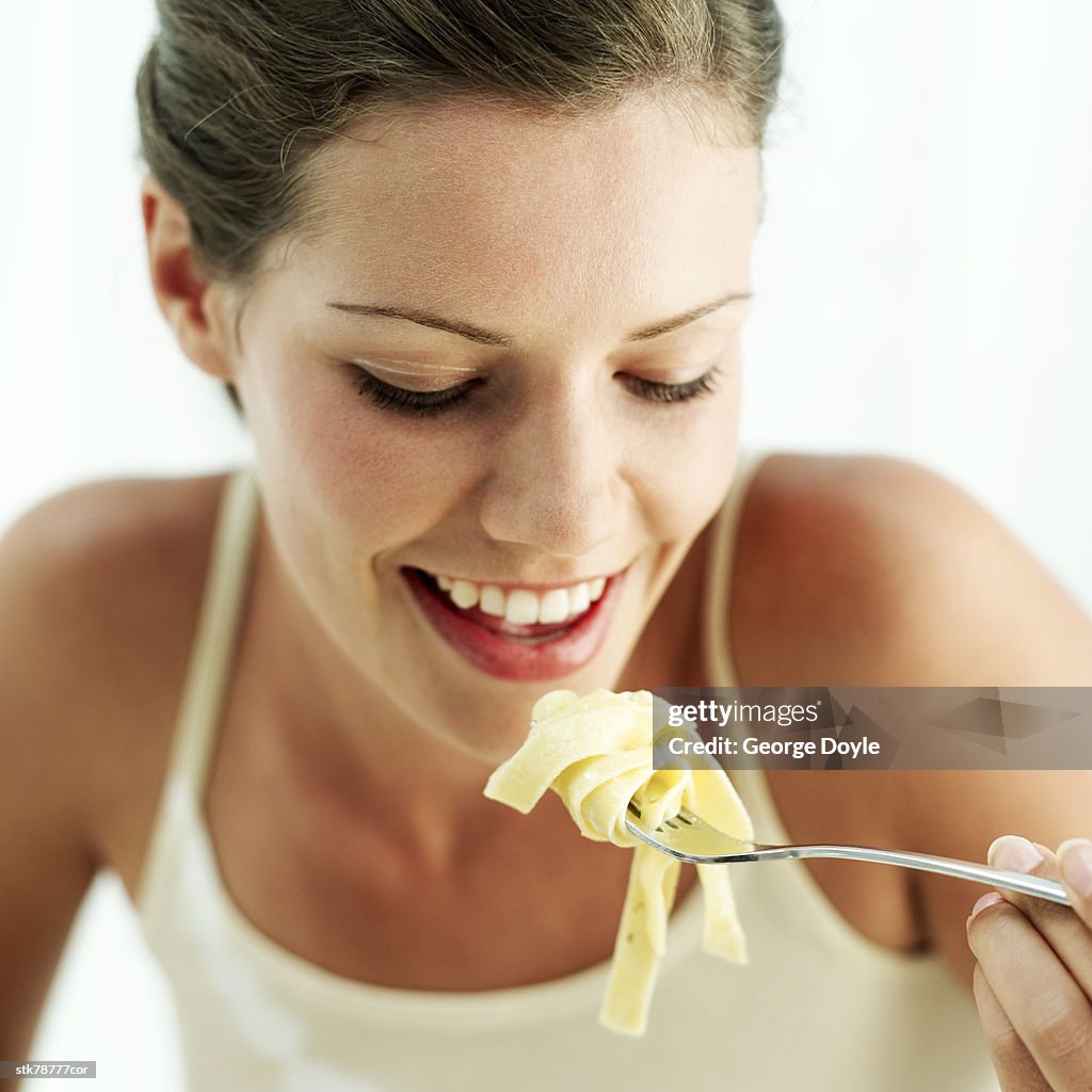 Portrait of a young woman eating pasta