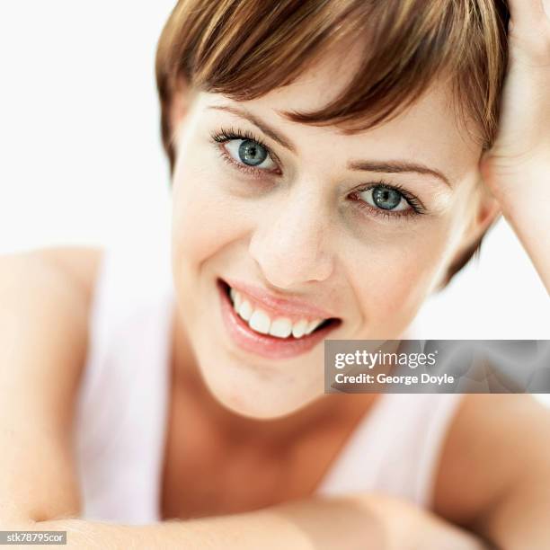 close-up of a woman smiling with her hand on her head - hand on head ストックフォトと画像