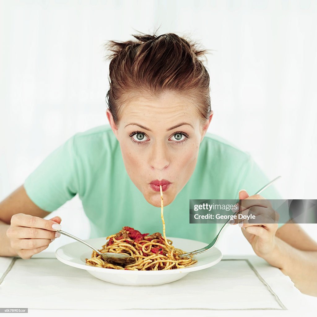 Portrait of a woman eating a plate of spaghetti
