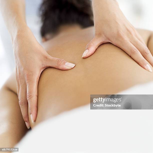 close-up of a masseuses' hands massaging a persons back - dorso umano foto e immagini stock