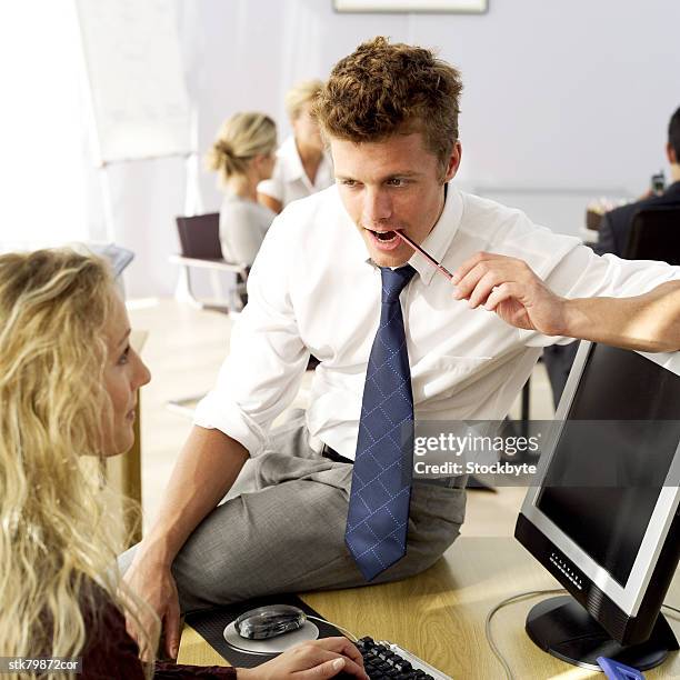 side profile of a young man and woman talking at work - in profile stock pictures, royalty-free photos & images