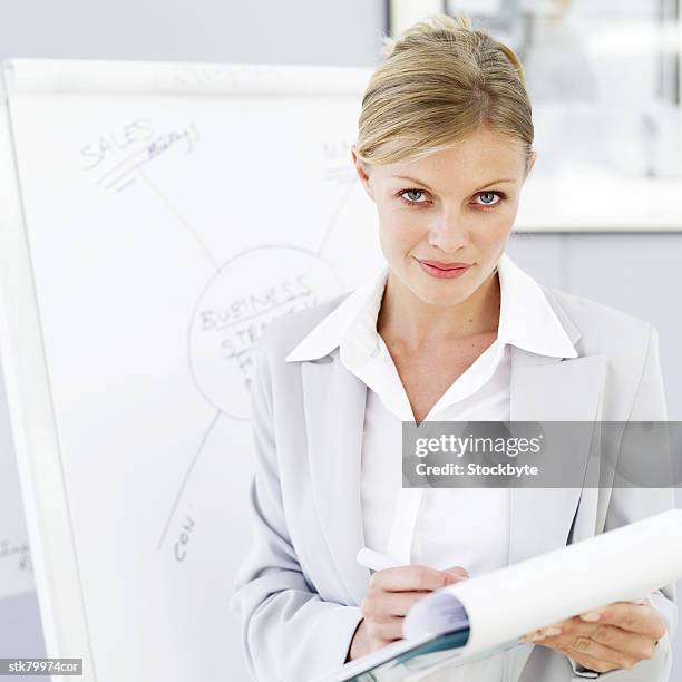 portrait of a young businesswoman making notes on a notepad - presentation of the book scenes de crime au louvre written by christos markogiannakis in paris stockfoto's en -beelden