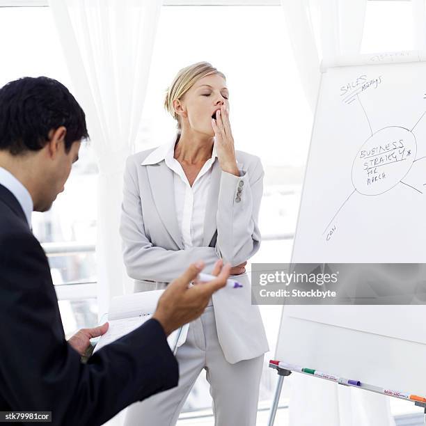 portrait of a young businesswoman yawning at a presentation - presentation of the book scenes de crime au louvre written by christos markogiannakis in paris stockfoto's en -beelden