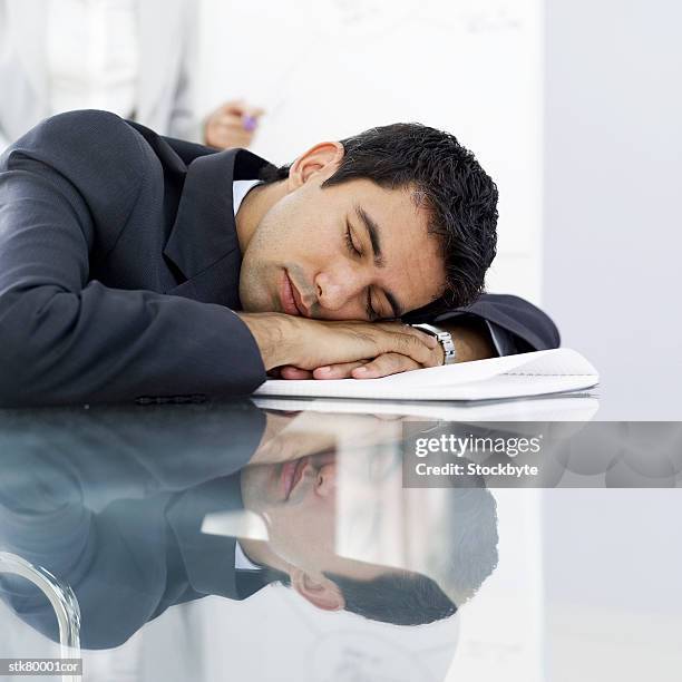 portrait of a young businessman sleeping at work - writing instrument stock pictures, royalty-free photos & images