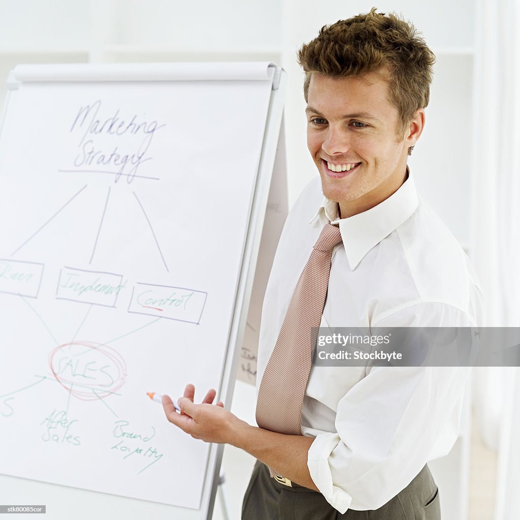 Businessman smiling explaining a flowchart