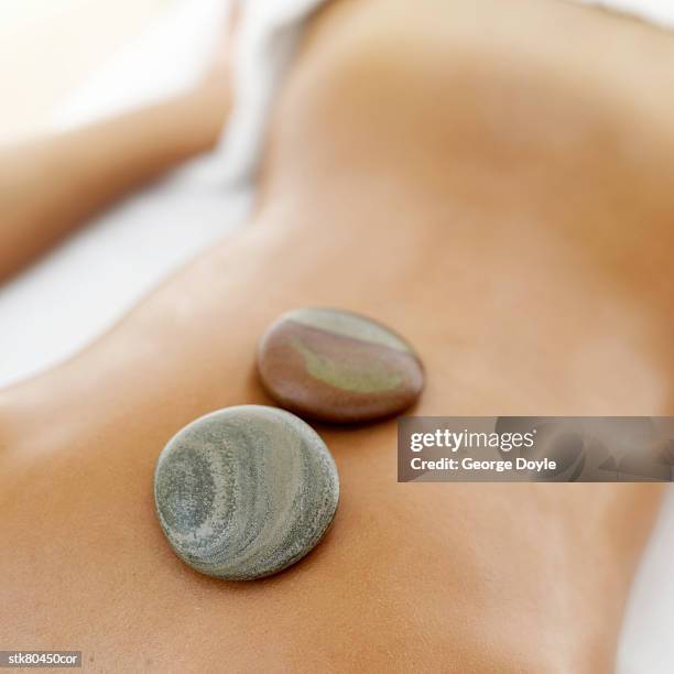 back of a woman undergoing stone therapy - espalda humana fotografías e imágenes de stock