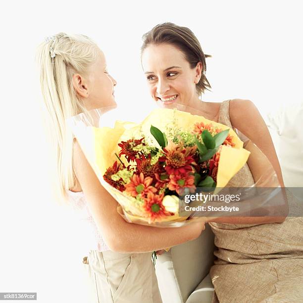 girl (6-7) giving a bouquet of flowers to a woman - temperate flowers stock-fotos und bilder