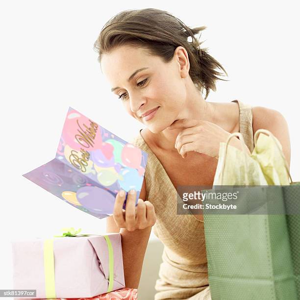 close-up of a woman reading a birthday card - alleen mid volwassen vrouwen stockfoto's en -beelden