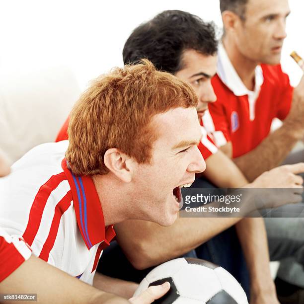 side profile of a group of football fans watching the game excitedly - in profile stock pictures, royalty-free photos & images