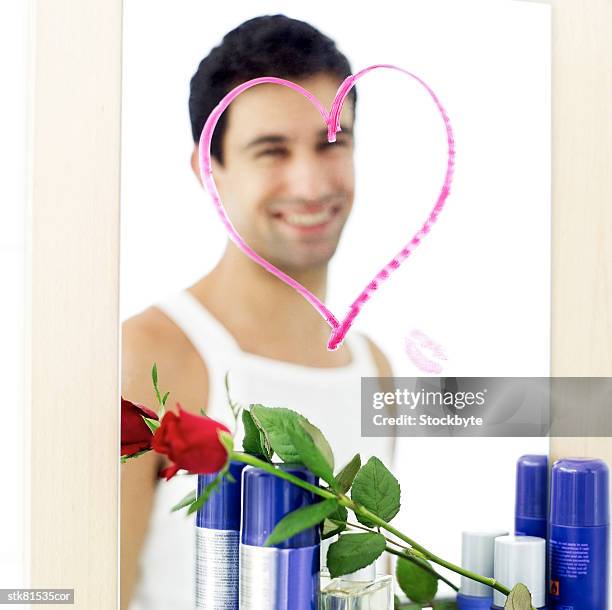 portrait of a young mans reflection framed by a lipstick drawn heart - rosaceae stock pictures, royalty-free photos & images