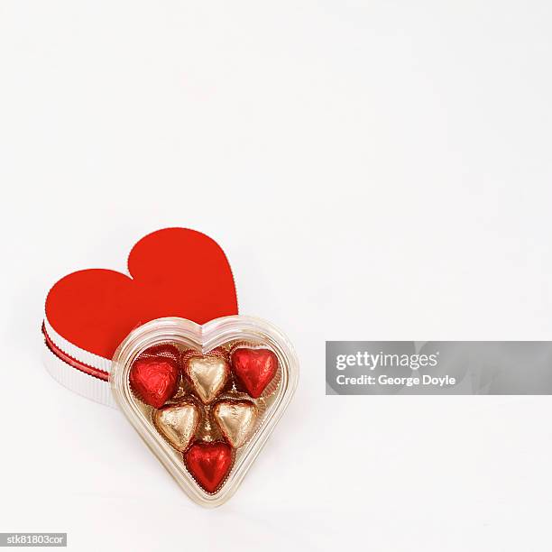 heart shaped box of chocolates - chocolate pieces stock-fotos und bilder