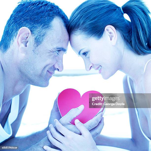 portrait of a young couple looking into each others eyes over a red heart - house and senate dems outline constitutional case for trump to obtain congressional consent before accepting foreign payments or gifts fotografías e imágenes de stock