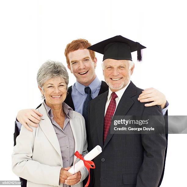 portrait of a young graduate standing with his parents - radius with the cinema society brooks brothers host the new york premiere of adult beginners stockfoto's en -beelden