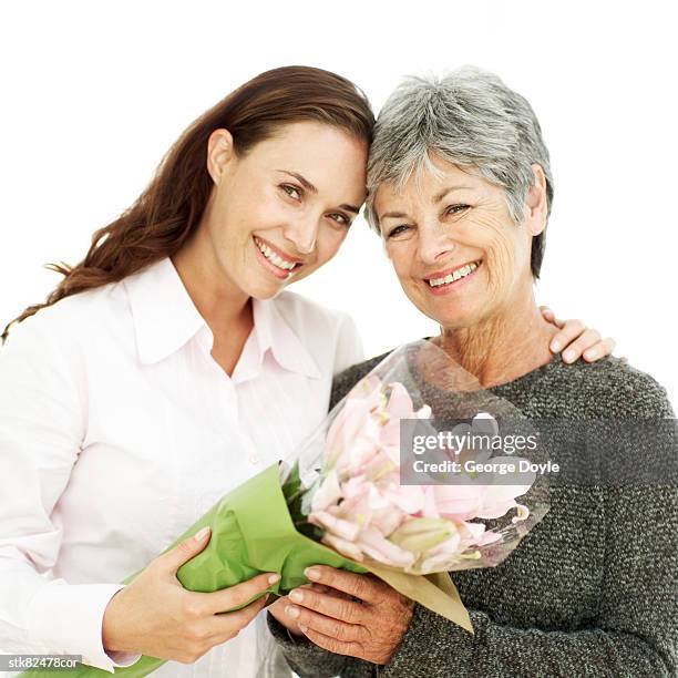 portrait of a mother and daughter holding a bouquet of flowers - open roads world premiere of mothers day arrivals stockfoto's en -beelden