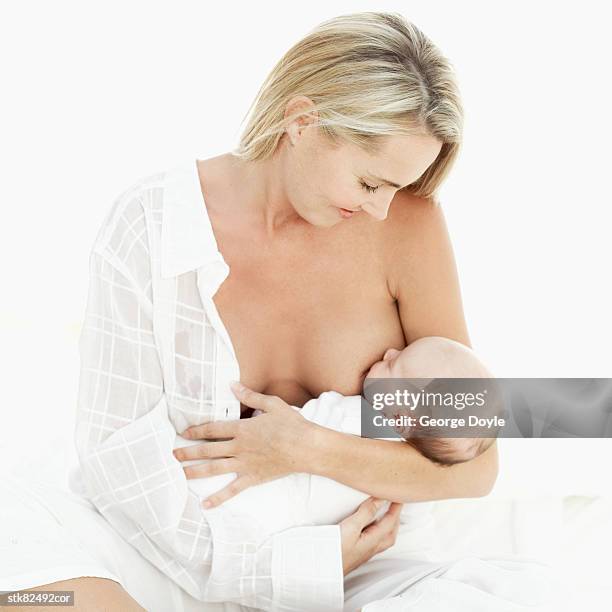 woman breastfeeding a baby (3-6 months) - unknown gender 個照片及圖片檔