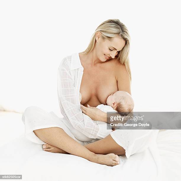 portrait of a woman breastfeeding a baby (3-6 months) - unknown gender stock pictures, royalty-free photos & images