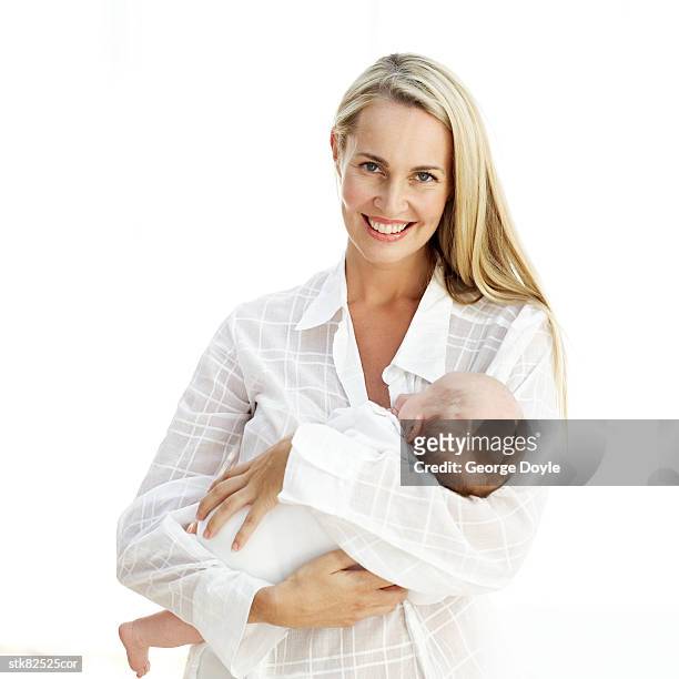portrait of a young mother carrying her baby - unknown gender stock pictures, royalty-free photos & images