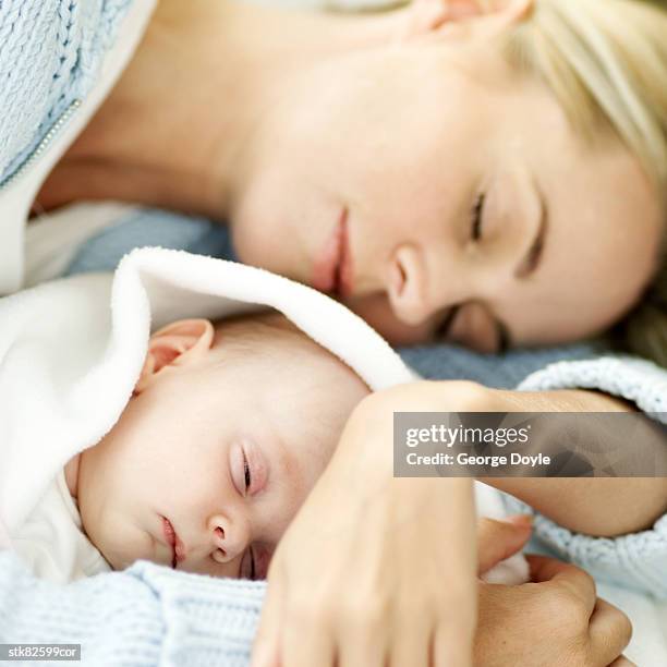 portrait of a young mother asleep holding her new born baby - unknown gender 個照片及圖片檔