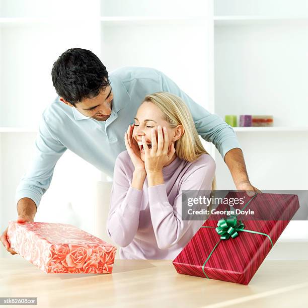 a young man giving gift wrapped presents to his girlfriend - house and senate dems outline constitutional case for trump to obtain congressional consent before accepting foreign payments or gifts stock pictures, royalty-free photos & images