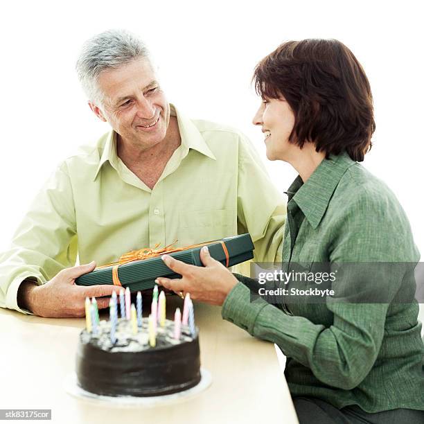portrait of a mature couple celebrating a birthday with a gift and cake - house and senate dems outline constitutional case for trump to obtain congressional consent before accepting foreign payments or gifts fotografías e imágenes de stock