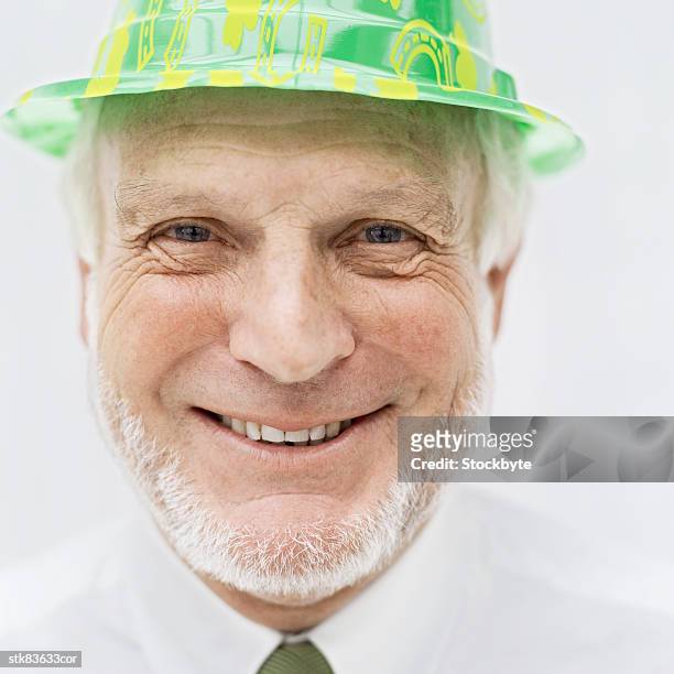 close-up of an elderly man wearing a plastic hat - hat stock-fotos und bilder