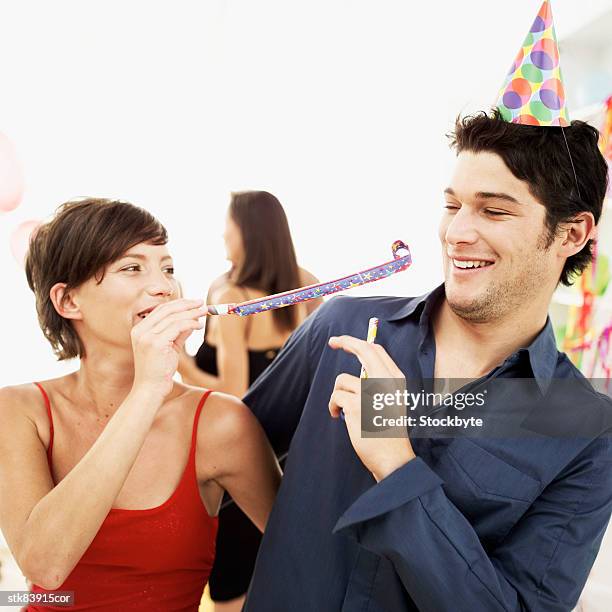 woman blowing a party blower at a man - tokyo governor and leader of the party of hope yuriko koike on the campaign trial for lower house elections stockfoto's en -beelden