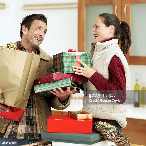 man and woman with christmas gifts - house and senate dems outline constitutional case for trump to obtain congressional consent before accepting foreign payments or gifts fotografías e imágenes de stock