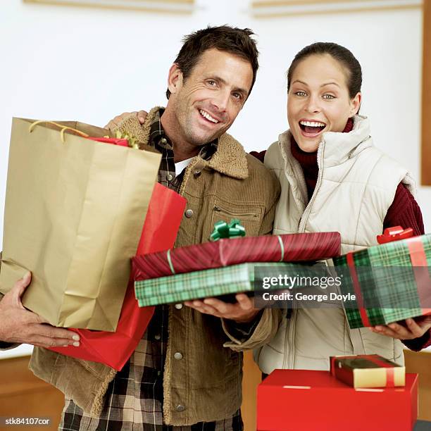portrait of a couple carrying bags of christmas presents - house and senate dems outline constitutional case for trump to obtain congressional consent before accepting foreign payments or gifts fotografías e imágenes de stock