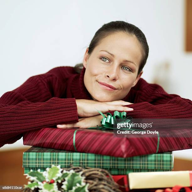 woman leaning christmas presents - house and senate dems outline constitutional case for trump to obtain congressional consent before accepting foreign payments or gifts stock pictures, royalty-free photos & images