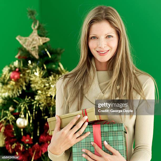 portrait of a woman holding christmas gifts - house and senate dems outline constitutional case for trump to obtain congressional consent before accepting foreign payments or gifts fotografías e imágenes de stock