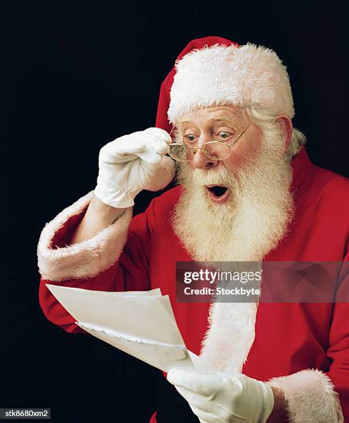 side profile of santa reading a letter with a shocked expression - in profile stock pictures, royalty-free photos & images