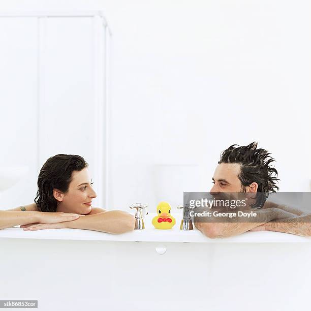 couple sitting in a bathtub and looking at each other - other stock-fotos und bilder