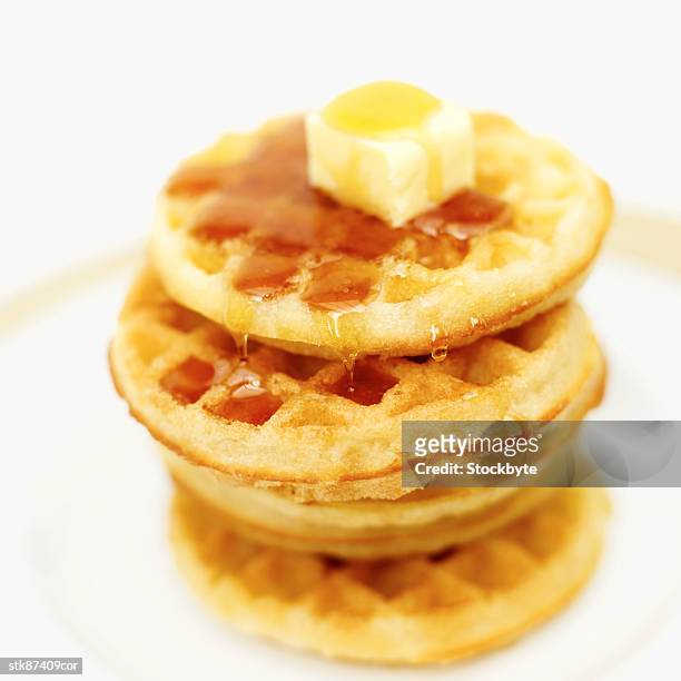close-up of butter melting on stack of waffles - stack foto e immagini stock