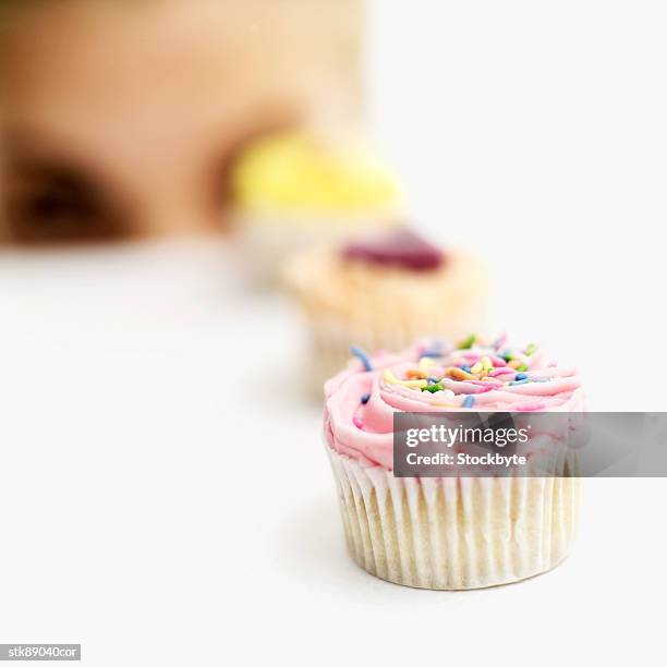 close-up of assorted cupcakes in a row (selective focus) - onbekend geslacht stockfoto's en -beelden