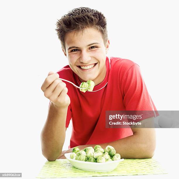 portrait of a teenage boy holding brussel sprouts on a fork - hungary v denmark 25th ihf mens world championship 2017 round of 16 stockfoto's en -beelden