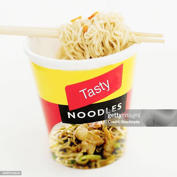 close-up of a cup of instant noodles with chopsticks - cup noodles stock-fotos und bilder