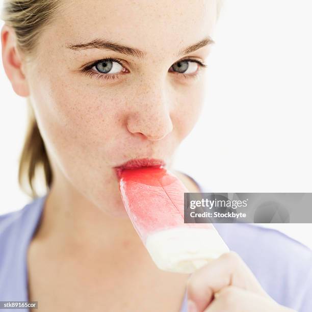 close-up of a teenage girl eating an ice lolly - gefrorene süßspeise stock-fotos und bilder