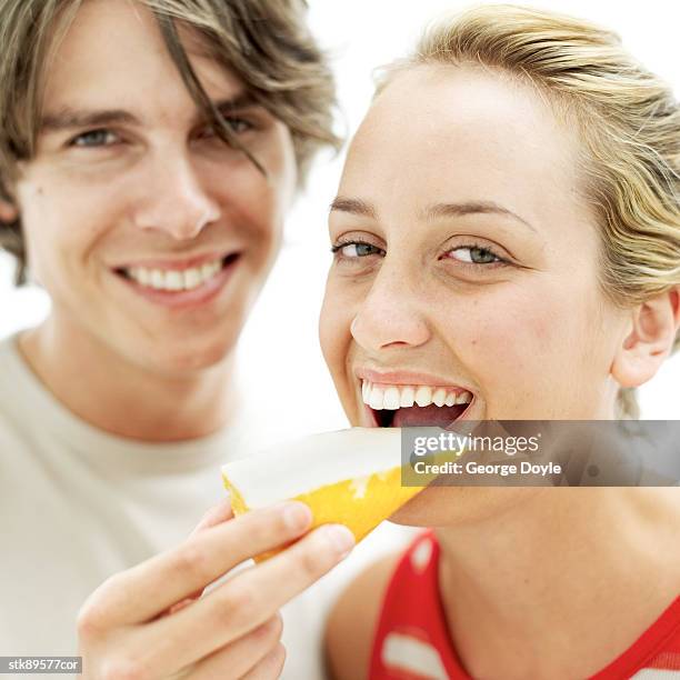 young man feeding young woman a slice of cheese - slice stock pictures, royalty-free photos & images