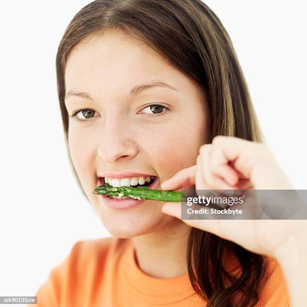 close-up of a teenage girl (15-16) eating a piece of asparagus - 1516 stock pictures, royalty-free photos & images