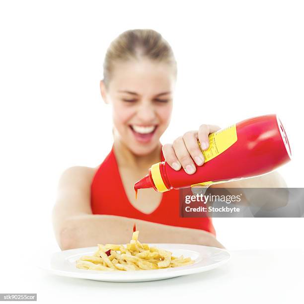 portrait of a young girl pouring ketchup onto a plate of french fries - hungary v denmark 25th ihf mens world championship 2017 round of 16 stockfoto's en -beelden