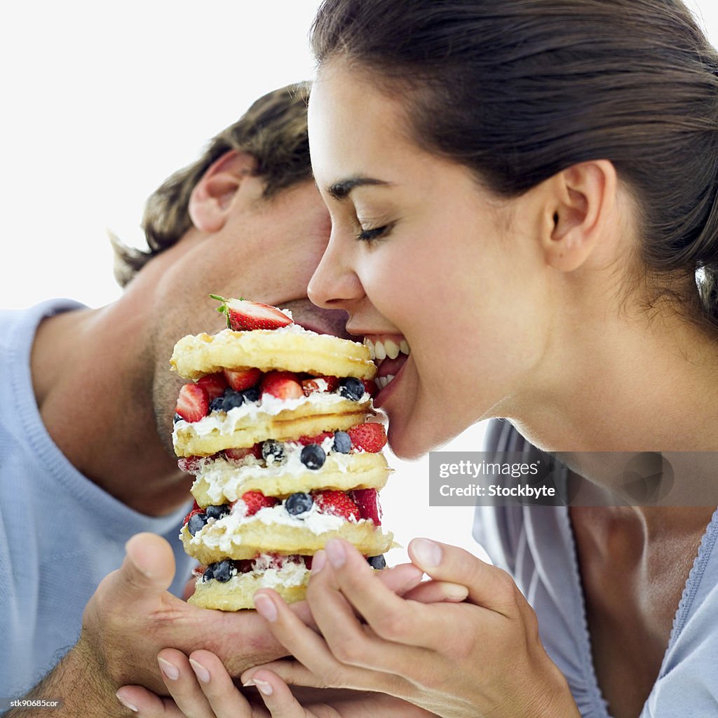 Close-up of a couple eating a fruit filled waffle tart