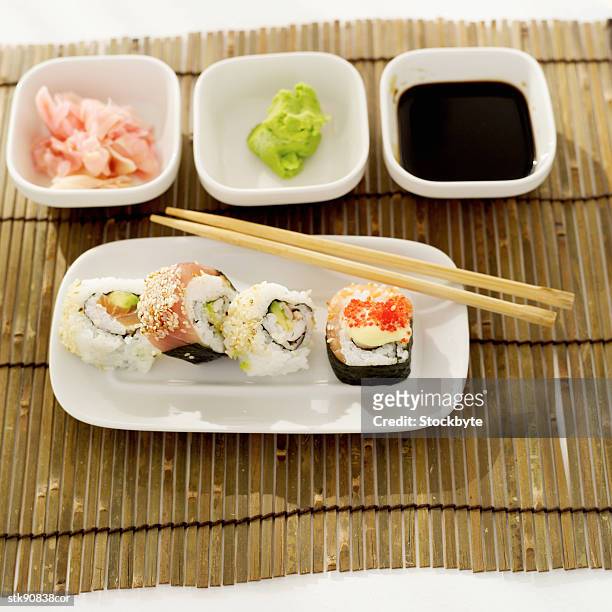 elevated view of a platter of assorted sushi rolls served with condiments - pickled ginger bildbanksfoton och bilder