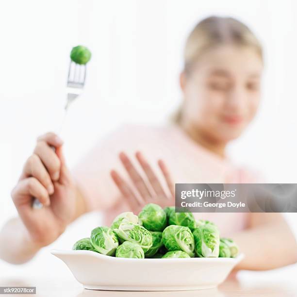 close-up of a woman's hand holding a brussels sprout on a fork (blurred) - hungary v denmark 25th ihf mens world championship 2017 round of 16 stockfoto's en -beelden