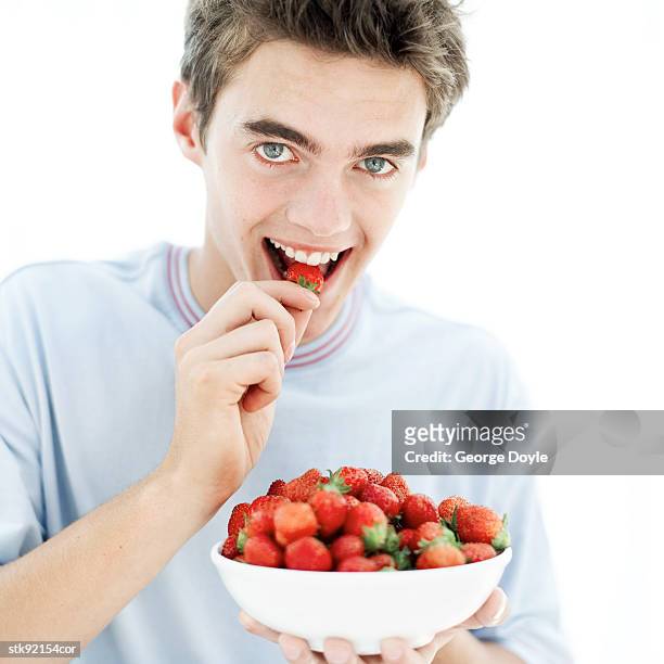 portrait of a young man eating from a bowl of strawberries - hungary v denmark 25th ihf mens world championship 2017 round of 16 stockfoto's en -beelden