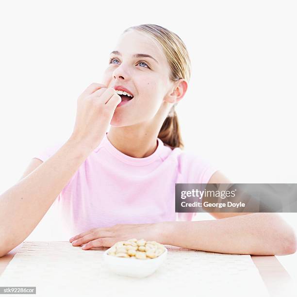 teenage girl (15-16) eating a peanut - 1516 stock pictures, royalty-free photos & images