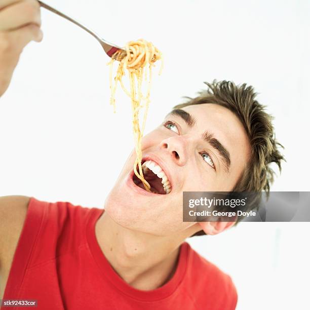 close-up of a teenage boy eating spaghetti with a fork - hungary v denmark 25th ihf mens world championship 2017 round of 16 stockfoto's en -beelden