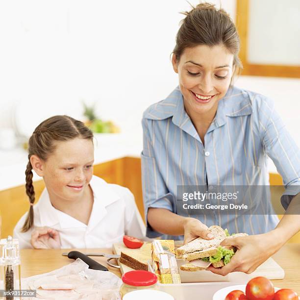 mother making her daughter's (6-7) school lunch - her stock pictures, royalty-free photos & images