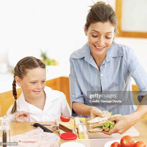 mother making her daughter's (6-7) school lunch - her bildbanksfoton och bilder