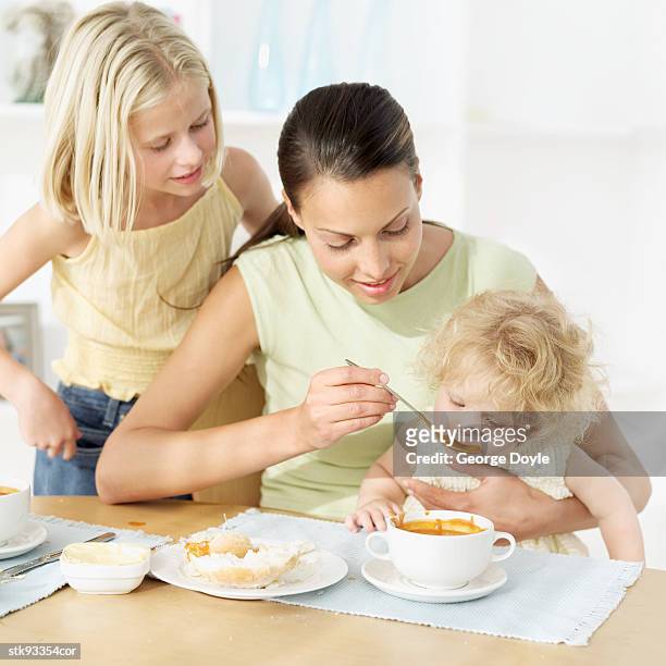 mother feeding her daughter (21-24 months) with soup - her fotografías e imágenes de stock