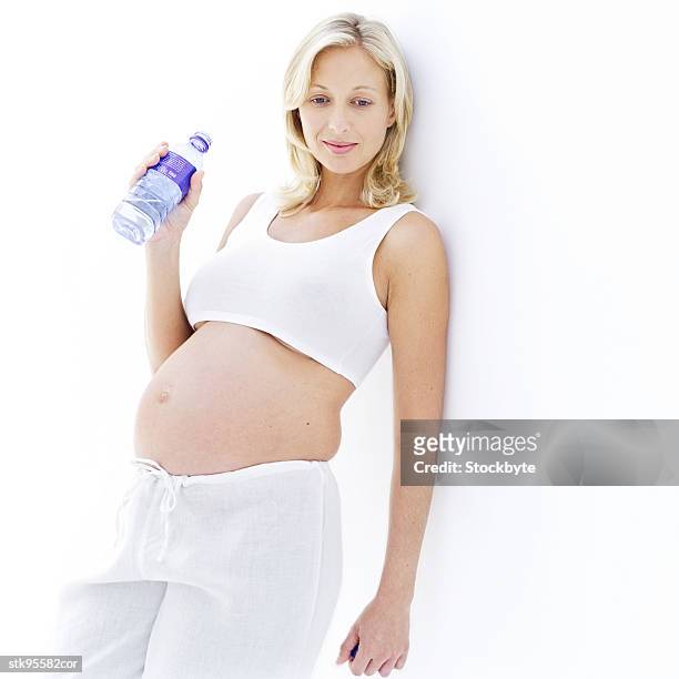 portrait of a young blonde pregnant woman with a bottle of water in her hand - her bildbanksfoton och bilder